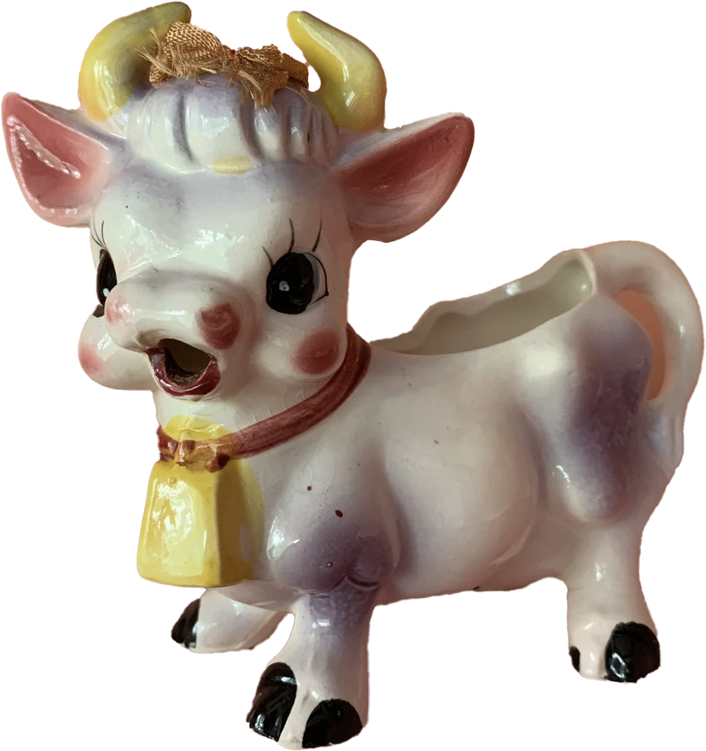 a porcelain statuette ofa happy cow with a bell