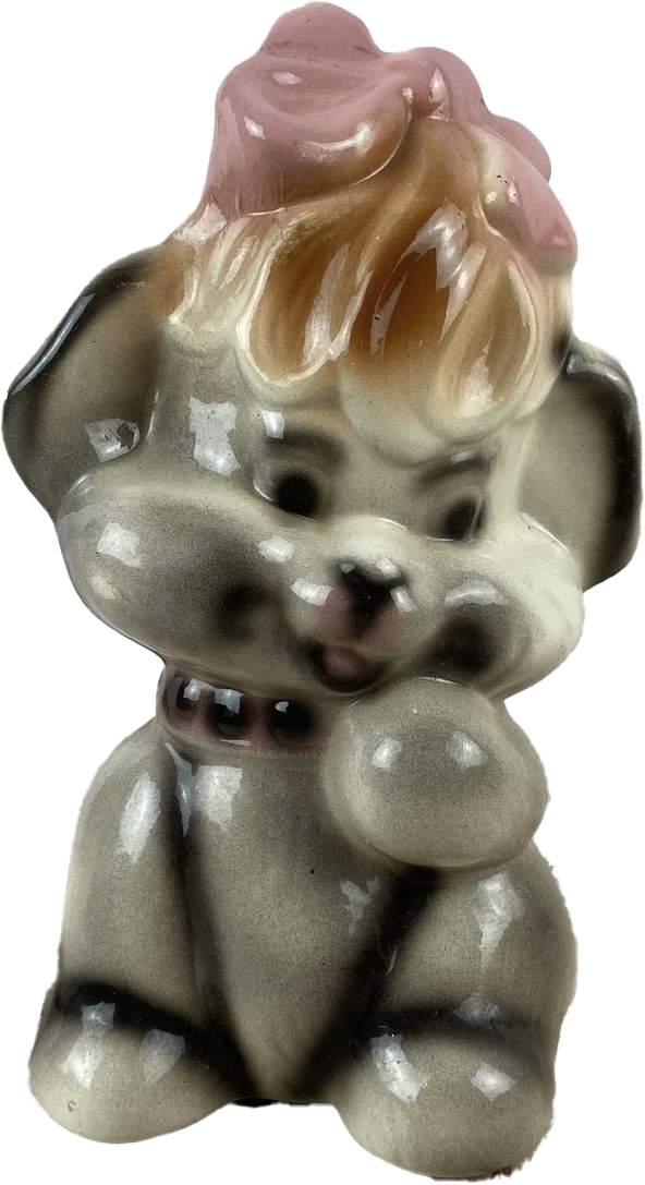 a porcelain statuette of a happy little dog with a pink bow