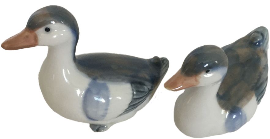 a porcelain statuette of two ducks sitting next to each other