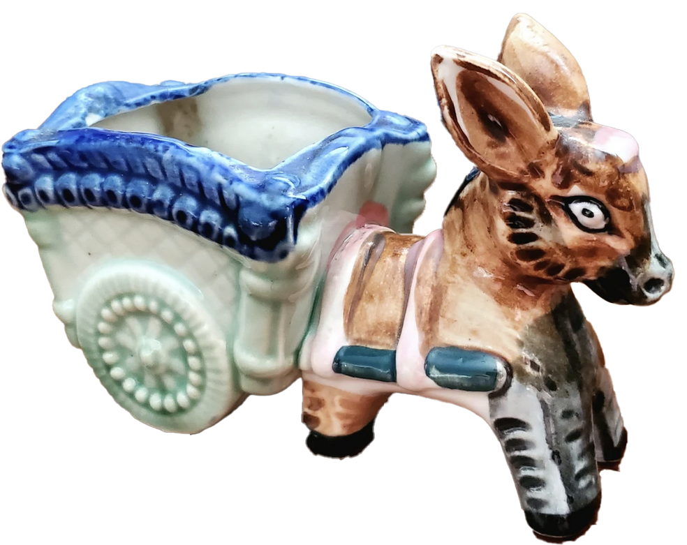 a porcelain statuette of a donkey  pulling a chariot